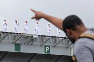 Crew members of the aircraft carrier USS Ronald Reagan line up on the flight deck after departing the U.S. Navy