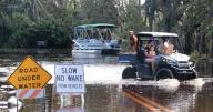 Residents in Geneva, Fla., navigate their flooded neighborhood on Mullet Lake Park Road following Hurricane Ian on Monday, Oct. 10, 2022. Floodwaters from the nearby St. Johns River put neighborhoods underwater. (Joe Burbank/Orlando Sentinel/TNS