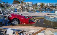 The front of a Mercedes Benz convertible sticks out of a pool in the back yard of a home on Estero Boulevard Wednesday, Oct. 26, 2022. The car ended up in the pool after Hurricane Ian slammed into the area as a Category 4 storm Wednesday, Sept. 28, 2022. (Pedro Portal/Miami Herald/TNS
