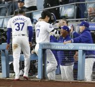 Shohei Ohtani (17) of the Los Angeles Dodgers is greeted by manager Dave Roberts (2nd from R) after hitting a solo home run, the season