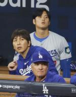 Shohei Ohtani (back) of the Los Angeles Dodgers and his interpreter Ippei Mizuhara (L) watch Major League Baseball