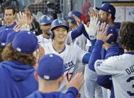 Los Angeles Dodgers designated hitter Shohei Ohtani is greeted by teammates in the dugout after hitting a two-run home run in the first inning of a baseball game against the Miami Marlins at Dodger Stadium in Los Angeles on May 6, 2024. (Kyodo) ==Kyodo