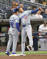 Shohei Ohtani (R) of the Los Angeles Dodgers performs a helmet touch with first base coach Clayton McCullough after walking to first base in the sixth inning of a baseball game against the San Diego Padres on May 11, 2024, at Petco Park in San Diego, California. (Kyodo) ==Kyodo