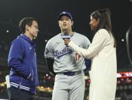 Los Angeles Dodgers designated hitter Shohei Ohtani (C) gives an interview after the team