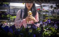 A shopper enjoys the unseasonably warm weather while she browses plants with her ice cream in the busy Union Square Greenmarket in New York on Wednesday, May 1, 2024 ( Richard B. Levine