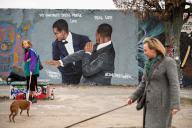 March 30, 2022 - Berlin, Germany, Europe: Two women walk their dogs in front of a graffiti by the artist Eme Freethinker on a segment of the Berlin Wall at Berliner Mauerpark in the borough of Prenzlauer Berg that depicts the actor Will Smith slapping the comedian Chris Rock in the face on stage during the 94th Academy Awards ceremony, after the comic made a joke about the actor