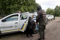KHARKIV REGION, UKRAINE - MAY 12, 2024 - An officer helps an elderly woman out from a police car during the evacuation of civilian population from Vovchansk city, constantly subjected to Russian shelling, Kharkiv region, northeastern Ukraine. (Ukrinform/Polaris