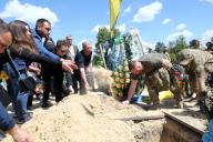KYIV REGION, UKRAINE - MAY 10, 2024 - People throw handfuls of soil into the grave of the soldier Yevhen Slyvka (call sign "Shaman"), who died on April 16, 2024, in a battle in Donetsk region, during a funeral ceremony on the Alley of Memory of the Defenders of Ukraine, Irpin, Kyiv region, northern Ukraine. (UKRINFORM/POLARIS