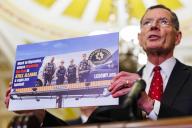 5\/15\/2024 - Washington, District of Columbia, United States of America: United States Senator John Barrasso (Republican of Wyoming) holds a photo of billboard in Wyoming advocating against funding police, during a weekly post-Senate policy luncheon press conference in the Capitol Building in Washington DC on Wednesday, May 15, 2024. (Aaron Schwartz \/ CNP \/ Polaris