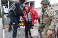 KHARKIV REGION, UKRAINE - MAY 17, 2024 - A police officer and a serviceman help an elderly woman go down a ramp during the evacuation from Vovchansk which is under constant Russian shelling, Kharkiv region, northeastern Ukraine. (Ukrinform/POLARIS