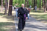 KYIV, UKRAINE - MAY 19, 2024 - A priest walks along an alley at the Bykivnia Graves National Historical and Memorial Reserve on the Day of Remembrance of the Victims of Political Repressions, Kyiv, capital of Ukraine. (UKRINFORM/POLARIS