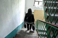 STEPNOHIRSK, UKRAINE - MAY 21, 2024 - A woman carrying two bags goes down the stairs in an apartment block opposite the settlement council building which a Russian guided bomb has hit during the evacuation, Stepnohirsk, Zaporizhzhia region, southeastern Ukraine. (Ukrinform/POLARIS