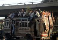 KARACHI, PAKISTAN, MAY 08: Passengers are traveling on a roof of an overloaded bus due to shortage of public transports in city, at Qayyumabad in Karachi on Wednesday, May 8, 2024. (S.Imran Ali\/PPI Images
