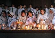 PESHAWAR, PAKISTAN, MAY 09: Students from Army Public School (APS) enlightened candles during their visit to Radio Pakistan building which was torched last year in the wake of May 9 riots, in Peshawar on Thursday, May 9, 2024. The government has decided to mark May 9 as black day on Thursday (today) in commemoration of the first anniversary of the violence against military installations throughout the country. (Fahad Pervez\/PPI Images