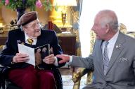 LONDON, ENGLAND - MAY 22: (STRICTLY EMBARGOED UNTIL JUNE 1st 00:01 BST) In this image released on June 1, King Charles III, Patron of the Royal British Legion, presents D-Day veteran Jim Miller with a card to mark his 100th birthday during a visit 