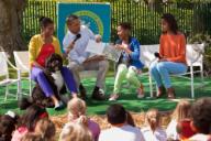 President Barack Obama, joined by First Lady Michelle Obama and daughters Sasha and Malia, reads "Where the Wild Things Are" during the 2012 White House Easter Egg Roll on the South Lawn, April 9, 2012. Bo, the Obama family dog, sits with them.
