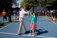 President Barack Obama high fives his doubles partner following a tennis drill on the White House Tennis Court during the 2012 White House Easter Egg Roll on the South Lawn, April 9, 2012. The pair played Chris Evert and her partner, a boy attending ...