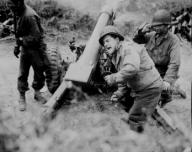 "American howitzers shell German forces retreating near Carentan France." Franklin July 11 1944. (Edisto Images)