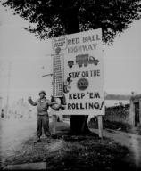 Corporal Charles H. Johnson of the 783rd Military Police Battalion waves on a `Red Ball Express