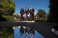 President Barack Obama walks with Prime Minister Stephen Harper of Canada, left, and President Felipe Calderon of Mexico following their joint press conference in the Rose Garden of the White House, April 2, 2012. The three leaders are reflected in ...