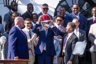 UNITED STATES - MAY 31: President Joe Biden dons a Kansas City Chiefs helmet as head coach Andy Reid, left, and owner Clark Hunt, right, look on, during an event to celebrate the Chiefsâ Super Bowl LVIII championship at the White House on Friday, May 31, 2024. (Tom Williams/CQ Roll Call