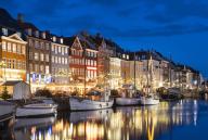 Colourful buildings and tall masted boats on the waterfront at Nyhavn at night, Nyhavn Canal, Nyhavn, Copenhagen, Denmark, Europe