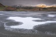 Ice Patterns on frozen Llyn y Dywarchen backed by Foel Goch and Foel Gronin in winter, Snowdonia National Park (Eryri), North Wales, United Kingdom, Europe