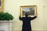 President Barack Obama adjusts a painting in the Oval Office, May 10, 2010. (Pete Souza/ PSG)