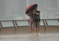 People hold umbrellas against the rain under the bad weather, at the waterfront in Tsim Sha Tsui. 28APR24. SCMP / Sam