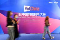 (240329) -- CHENGDU, March 29, 2024 (Xinhua) -- Participants walk past a signboard of the 11th China Internet Audio and Video Convention in Chengdu, southwest China\'s Sichuan Province, March 28, 2024. The 11th China Internet Audio and Video Convention, demonstrating a series of cutting-edge technologies, opened on Thursday in Chengdu, capital of southwest China\'s Sichuan Province. Focusing on innovation and industrial upgrades, the three-day event has attracted participating enterprises to display their technologies in 5G+8K, 3D, cloud gaming and other sectors. (Xinhua\/Tang Wenhao) - Tang Wenhao -\/\/CHINENOUVELLE_CHINENOUVELLE0017\/Credit:CHINE NOUVELLE\/SIPA