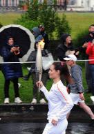French torchbearer Marlene Bouchisse carries the Olympic torch as part of the Olympic flame relays, with a view of the Basilique Notre Dame du Rosaire (L) in Lourdes, south-western France, on May 18, 2024. //FOURCADEFERNAND_1904.09458/Credit:Fernand Fourcade/SIPA