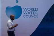 (240520) -- BALI, May 20, 2024 (Xinhua) -- A man walks past a sign of the World Water Council at the Fair and Expo of the 10th World Water Forum in Bali, Indonesia, May 20, 2024. The 10th World Water Forum under the theme of "Water for Shared Prosperity" officially opened on Indonesia