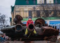With a defiant attitude, a child sits on the canon of a tank destroyed by Ukrainian armed forces in Kiev. After a year of war, the situation remains uncertain. Towns such as Kyiv are regaining an apparent normality of daily life. (Photo by Mario Coll / SOPA Images/Sipa USA