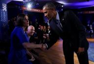 US President Barack Obama shakes hands with Taya Kyle (L), widow of U.S. Navy SEAL Chris Kyle, during the commercial break of a live town hall event with CNN