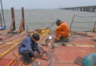 Construction workers seen working on a barge vessel opposite the bow string arch bridge (not in picture) connecting coastal road to Bandra Worli sealink installed at the Worli (area in South Mumbai) end in Mumbai. (Photo by Ashish Vaishnav \/ SOPA Images\/Sipa USA