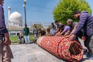 Workers are stretching the largest carpet on a path near the Hazratbal shrine to let it dry in the sun. In the wake of Srinagar being honored as one of the most creative cities globally, Kashmir\'s artisans are striving to meet the expectations of this prestigious title. In the village of Wayil in North Kashmir\'s Kralpora region, a team of Kashmiri artisans has revealed a masterpiece hailed as Asia\'s largest handcrafted carpet. This hand-knotted Kashmiri carpet spans an impressive 72 feet by 40 feet, covering a vast area of 2,880 square feet. It took more than 25 artisans over eight years to complete this extraordinary piece. The entire carpet industry in the Kashmir valley takes immense pride in this achievement. The intricate weaving of this exceptional carpet was overseen by two seasoned veterans of the craft, Fayaz Ahmed Shah and Abdul Gaffar Sheikh, whose steadfast dedication ensured the completion of this monumental work despite numerous challenges. (Photo by Idrees Abbas \/ SOPA Images\/Sipa USA