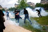 Protesters kick teargas back towards riot police. Violent clashes erupt as thousands of protesters and trade unions gather in Paris for this year\'s International Workers Day.?Originally a day to celebrate labourers and the working class, this year sees a continuation of protests against president Macrons leadership.?Heavy clashes erupted as anti-capitalists joined the march, engaging in street battles with riot police; hurling bricks, bottles and smashing shop windows. Police responded with tear gas and baton charges. (Photo by Christopher Walls \/ SOPA Images\/Sipa USA