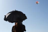 A festival goer under a parasol watches a large kite flying at the Sagami Giant Kite Festival (Sagami no Oodako). The festival started in the 1830s Giant kites, some over 15 metres tall, made with bamboo and handmade paper are flown on the Sagami riverside by teams from the surrounding cities. (Photo by Damon Coulter \/ SOPA Images\/Sipa USA