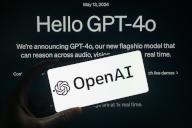 OpenAi is displayed on a smartphone with the announcing of GPT-4o visible in the background in this photo illustration. Taken in Brussels, Belgium. On May 13, 2024. (Jonathan Raa / Sipa USA) *** Strictly for editorial news purposes only 
