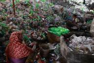 A Bangladeshi woman works in a plastic bottle recycling factory in Dhaka, Bangladesh, May 14, 2024. Workers are sorting discarded plastic bottles collected from the garbage heap and preparing them for recycling. These bottles are cleaned and cut into pieces by a cutting machine. There, new products are made from these pieces of plastic. According to the Environment Department of Bangladesh, about 24 thousand tons of waste is produced every day in the country. Of this 7.35 percent waste are plastic materials, which is 1,700 tones. Only 50 percent of these plastic wastes are recyclable. Photo by Suvra Kanti Das/Abaca/Sipa
