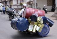 Surat, May 13, 2024 (ANI): A man rides a two-wheeler loaded with tin boxes and cylinders on a hot summer day, in Surat on Monday. (ANI Photo via Hindustan Times/Sipa USA