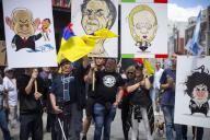 Protesters hold placards with the caricatured faces of politicians, Benjamin Netanyahu, Jair Bolsonaro, Giorgia Meloni and Javier Milei, during a rally in the Plaza de Callao in Madrid, under the slogan 