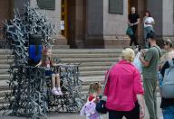 A man takes a photograph of a child sitting on the ìThrone of the Winnerî in the center of Kyiv amid the Russian invasion of Ukraine. The installation is made of approximately 200 metal drones. The weight of the throne is about 350ñ400 kg, at a height of 2.7 meters. ìThrone of the Winnerî is shown in Kyiv and then in other cities in Ukraine. The installation will be put up for auction, and the income will be used to buy combat drones. (Photo by Sergei Chuzavkov / SOPA Images/Sipa USA