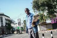 Kennedy Ahoya, waits for customers to buy his newspaper on Kenyatta Avenue in Nakuru Central Business District. Kennedy Ahoya, born in 1968, has been vending newspapers in Nakuru Town for the past 15 years, and says sales have been plummeting as more young people choose to read their news on social media, avoiding traditional newspapers. On a good day when he started selling newspapers, he would sell upwards of 150 copies in a day, today he can hardly sell 80 copies. (Photo by James Wakibia / SOPA Images/Sipa USA