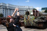 A girl takes a photo of a a destroyed Russian tank on display in central Kyiv. (Photo by Oleksii Chumachenko / SOPA Images/Sipa USA