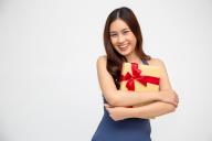 Happy beautiful asian woman smile with gold gift box isolated on green background. Teenage girls in love, Receiving gifts from lovers. New Year or Christmas concept