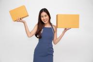 Happy Asian woman holding package parcel box, Delivery courier and shipment service concept