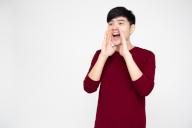 Portrait of excited screaming young asian man isolated over white background, Wow and surprised concept