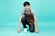 Young Asian startup barista owner man in the starting position isolated on light green background