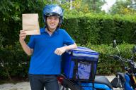 Young Asian man with delivery box, Motorcycle delivering food express service concept